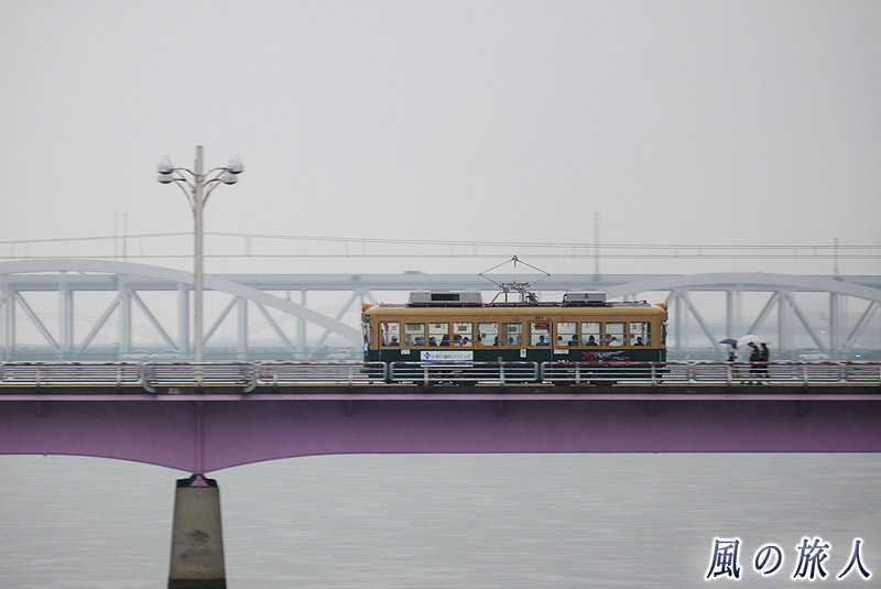 新己斐橋を渡る電車　雨の日の平和大通り2016の写真