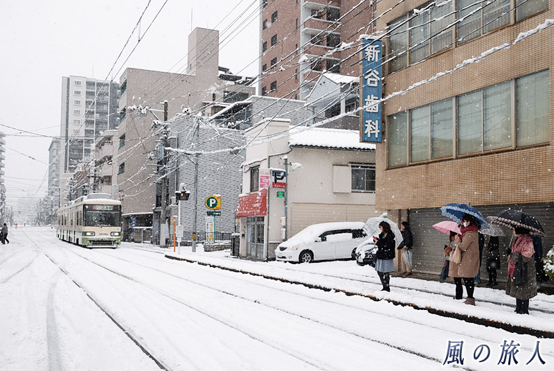 天満町電停で電車待ちをする人々　大雪の日2017の写真