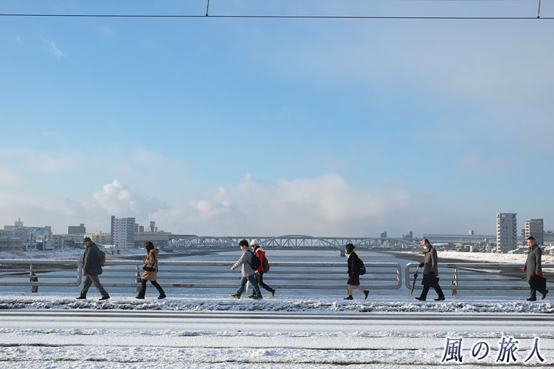 橋を歩く人々　凍結の新己斐橋の写真