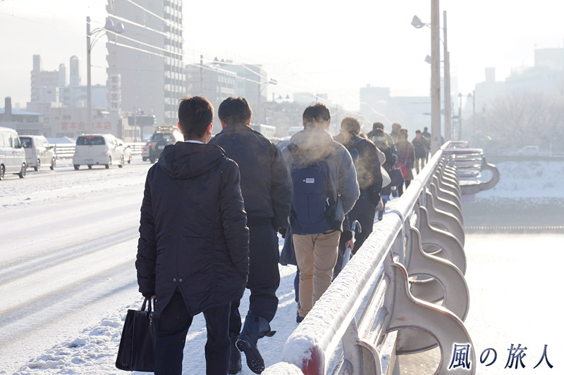 橋を歩く人の列　凍結の新己斐橋の写真