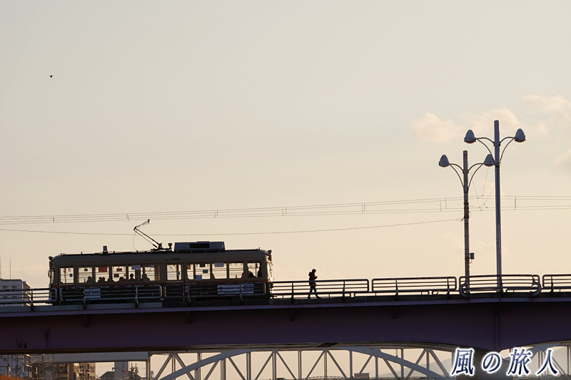 路面電車と歩く人　新己斐橋の夕景2017の写真