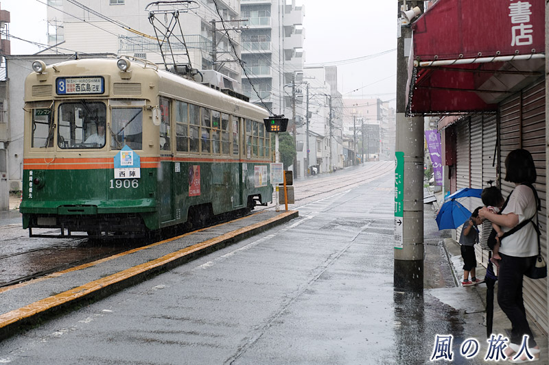 雨の中の電車待ち　雨の天満町と七夕電車の写真
