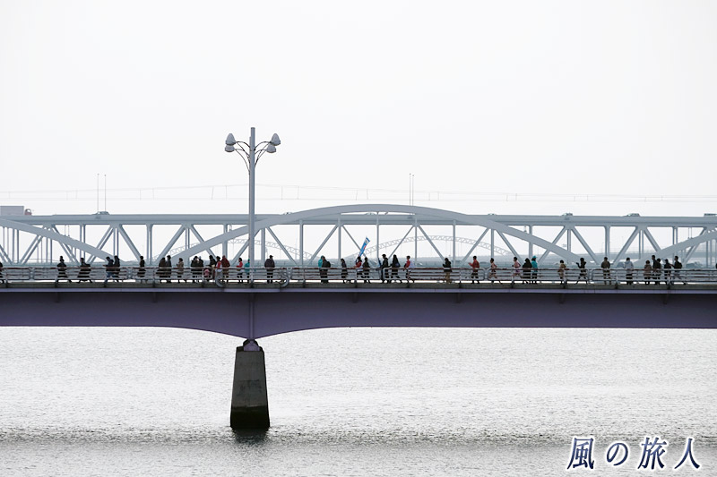 ランナーと応援する人　駅伝の日の新己斐橋の写真
