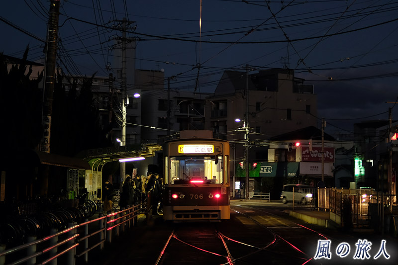 家路へ　夕闇迫る冬の江波電停の写真