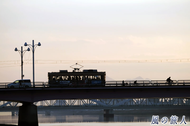 自転車と電車１　新己斐橋の夕景の写真