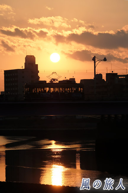 夕日と電車　新己斐橋の夕景の写真