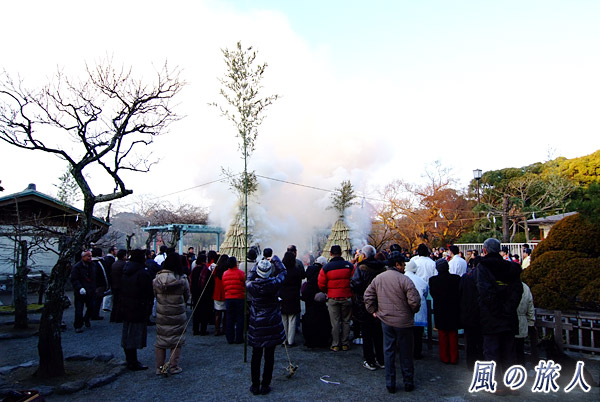 煙の上がるサイトと見守る人々　鶴岡八幡宮の左義長神事の写真