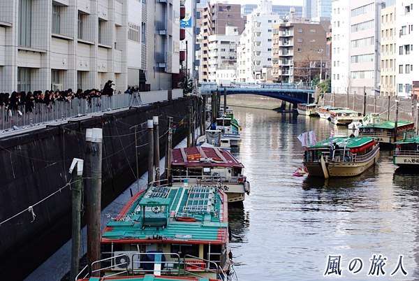日本橋女学館流し雛　学校から見守る生徒と屋台船からの流し雛の写真