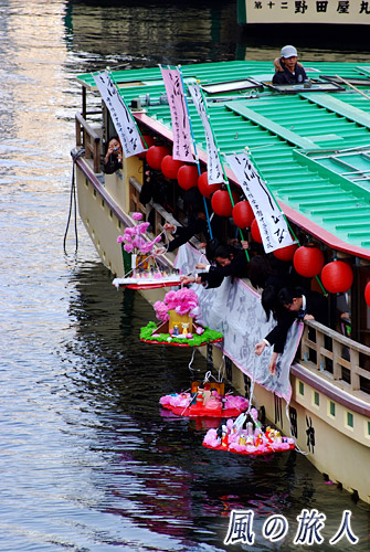 日本橋女学館流し雛　雛を水面に降ろす様子の写真