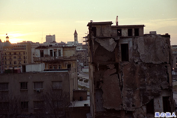 ぼろぼろのビルと夕日　ベイルートに残る内戦の傷跡の写真