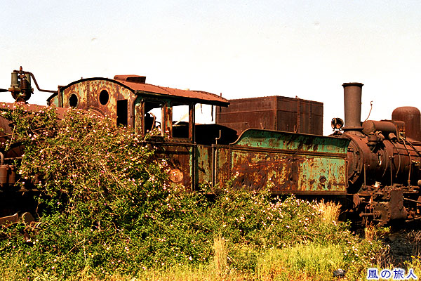 草に覆われる蒸気機関車　旧トリポリ駅の戦災蒸気機関車の写真