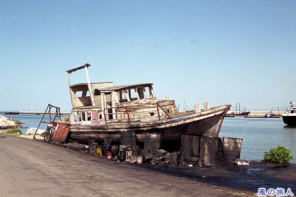 港に置かれた船　トリポリの町並みの写真